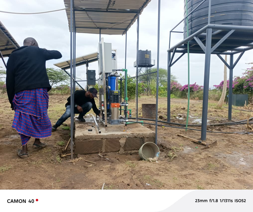 AfriFlux team installing solar pump system with water storage tank